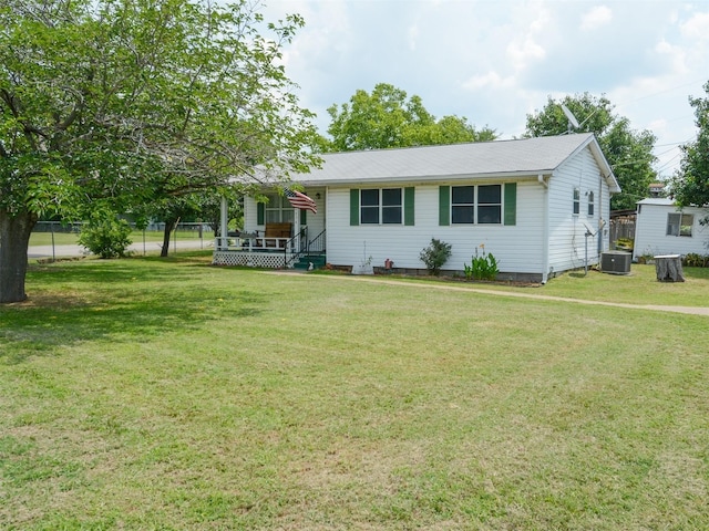 single story home featuring a front lawn, fence, and central air condition unit