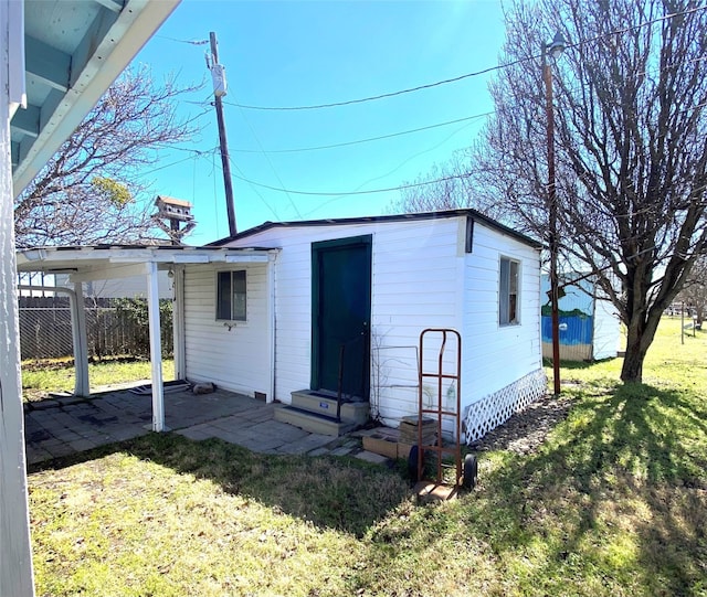 view of outbuilding with entry steps, fence, and an outdoor structure