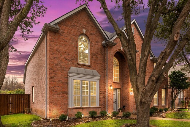 traditional home with brick siding and fence