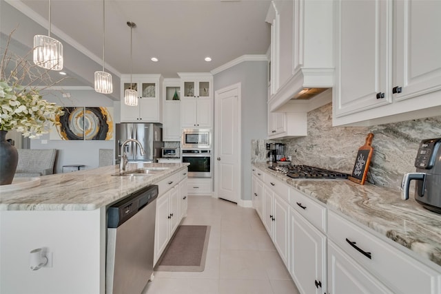 kitchen featuring appliances with stainless steel finishes, crown molding, a sink, and light tile patterned floors