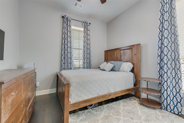 bedroom featuring a ceiling fan, dark wood-style flooring, visible vents, and baseboards