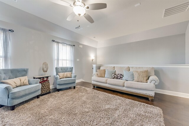 living room featuring ceiling fan, wood finished floors, visible vents, and baseboards