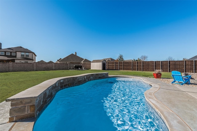 view of swimming pool with a fenced backyard, a shed, an outbuilding, and a yard