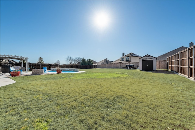 view of yard with an outbuilding, a fenced backyard, a pergola, a shed, and a patio area