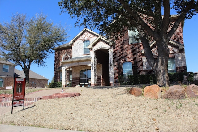 view of front facade featuring stone siding and brick siding