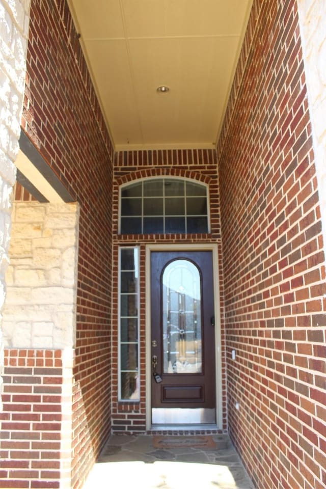 doorway to property with brick siding