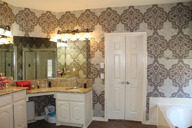 full bathroom featuring a garden tub, vanity, a closet, a shower stall, and wallpapered walls