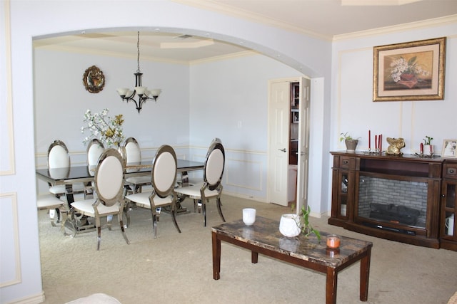 dining room with arched walkways, a notable chandelier, a decorative wall, ornamental molding, and carpet flooring