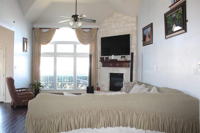 living room featuring ceiling fan, a fireplace, vaulted ceiling, and dark wood-style flooring