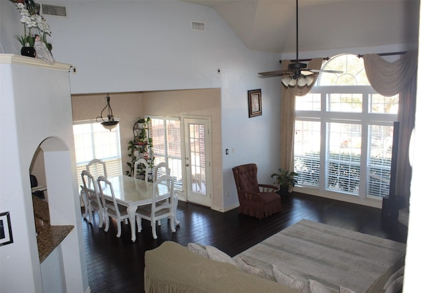 dining area with high vaulted ceiling, visible vents, ceiling fan, and hardwood / wood-style floors