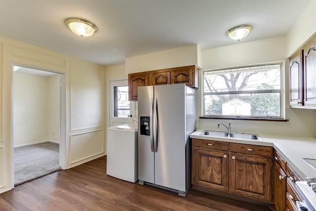 kitchen featuring dark wood-style floors, stainless steel fridge, washer / clothes dryer, and a sink