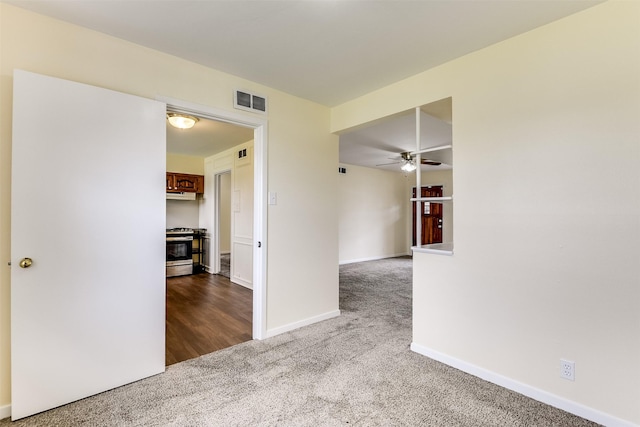 carpeted empty room featuring visible vents, ceiling fan, and baseboards