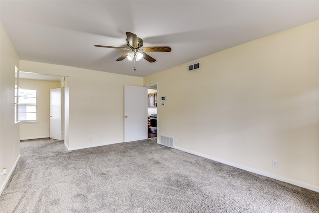 unfurnished room with baseboards, carpet flooring, visible vents, and a ceiling fan