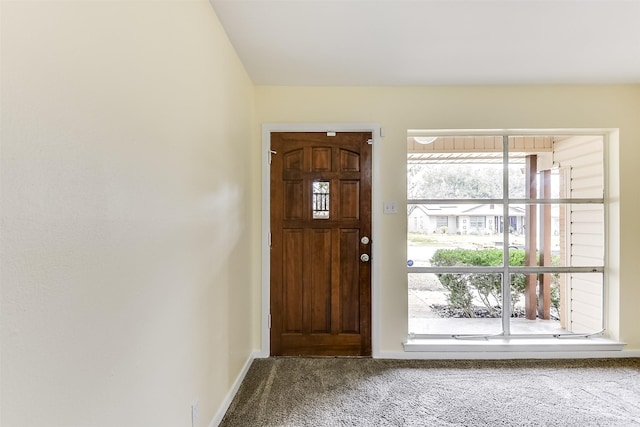 entrance foyer featuring baseboards and carpet flooring