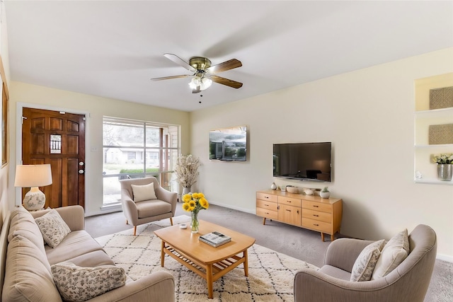 living area with light colored carpet, ceiling fan, and baseboards