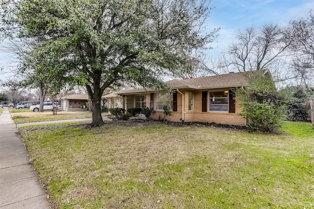 ranch-style house with a front lawn and brick siding