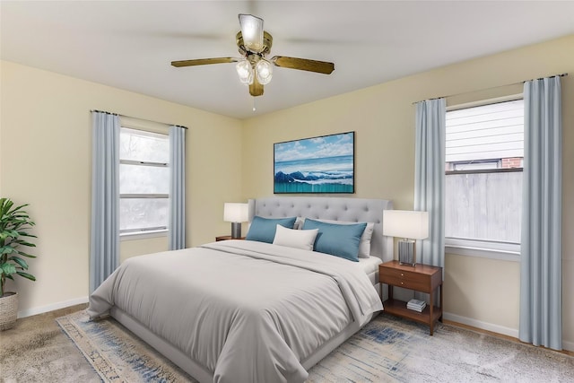 carpeted bedroom with a ceiling fan and baseboards