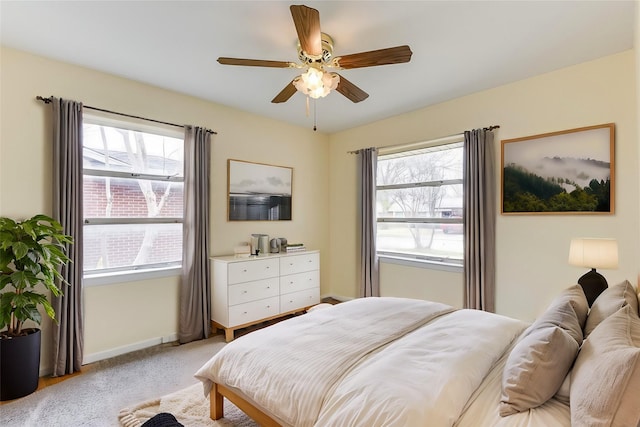 bedroom with light carpet, ceiling fan, and baseboards