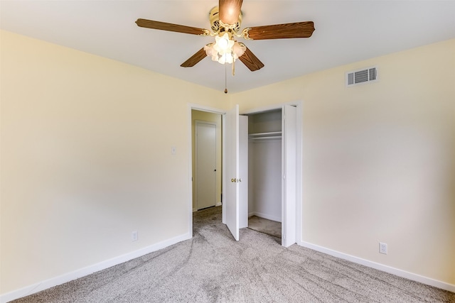 unfurnished bedroom featuring a closet, light colored carpet, visible vents, a ceiling fan, and baseboards