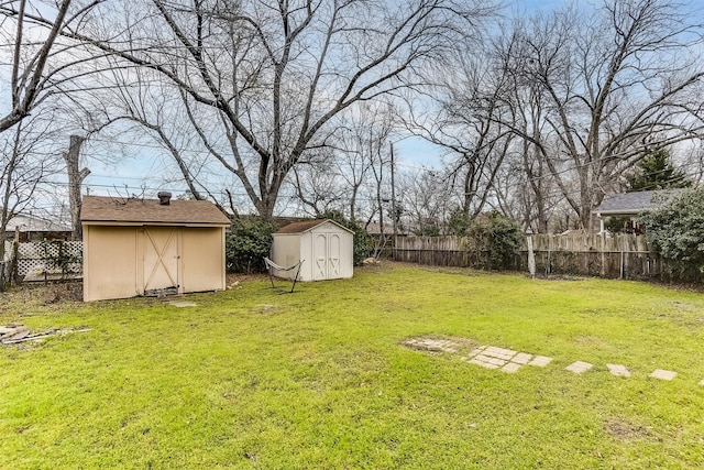 view of yard with an outbuilding, a storage unit, and fence