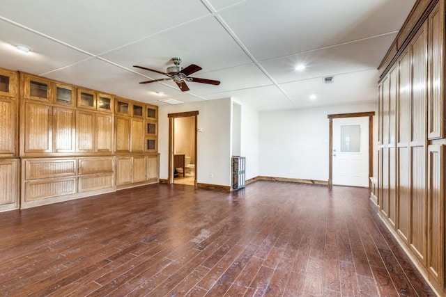 empty room featuring dark wood-style floors, ceiling fan, and baseboards