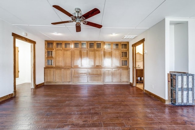 empty room featuring dark wood-style floors, visible vents, ceiling fan, and baseboards