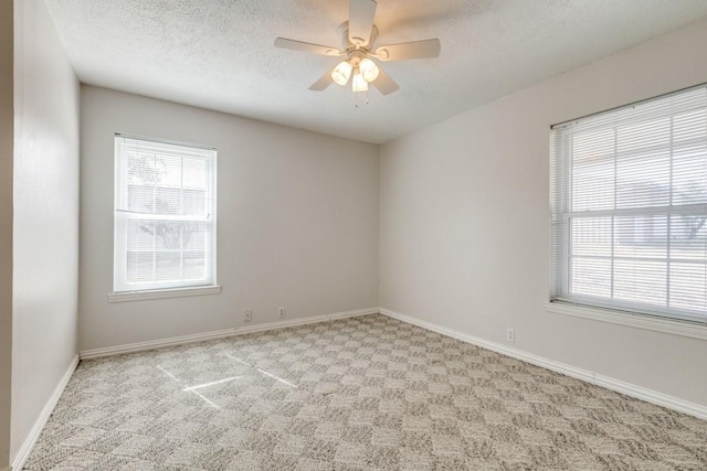 spare room featuring baseboards, carpet, a ceiling fan, and a textured ceiling