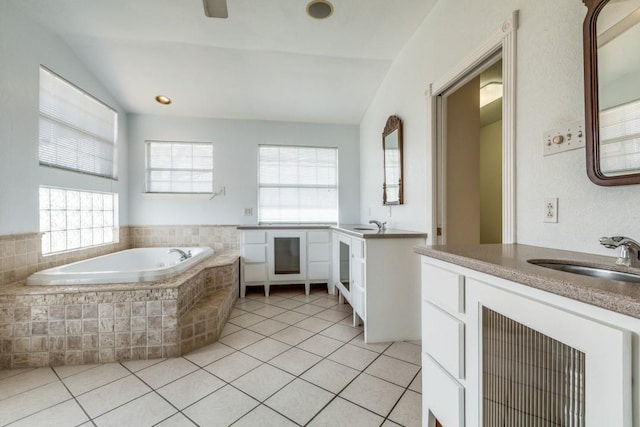 full bath featuring a bath, two vanities, a sink, and tile patterned floors