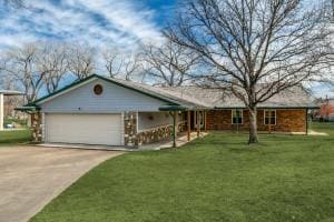 ranch-style house with a garage, a front yard, and concrete driveway