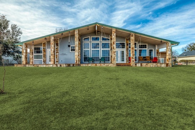 view of front of house with french doors, a front yard, and fence