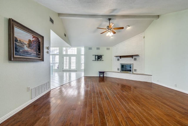 unfurnished living room with a textured ceiling, a fireplace, wood-type flooring, and visible vents