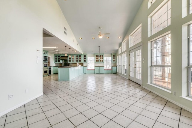 11484 Moran Rd, Azle, TX 76020 - unfurnished living room featuring light tile patterned floors, ceiling fan, baseboards, a towering ceiling, and recessed lighting