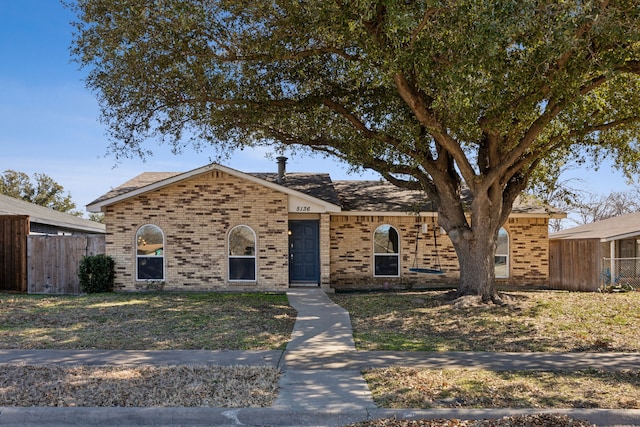 view of front of property with fence and brick siding