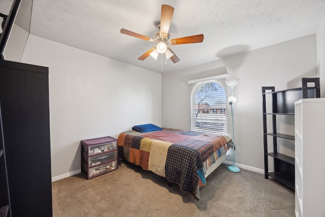 bedroom featuring a textured ceiling, carpet, a ceiling fan, and baseboards