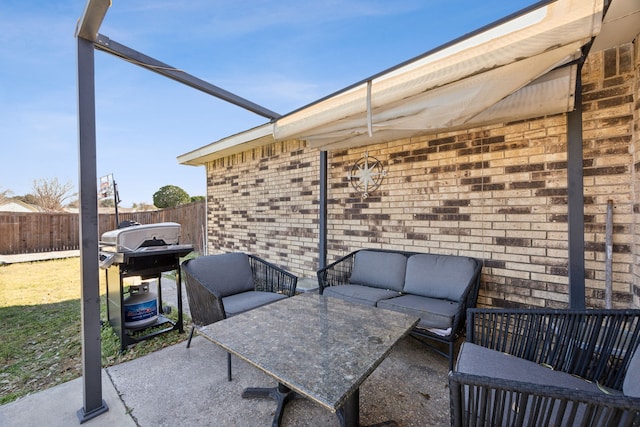 view of patio with fence, an outdoor living space, and area for grilling