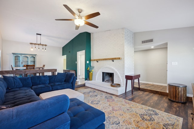 living area with baseboards, visible vents, lofted ceiling, wood finished floors, and a fireplace