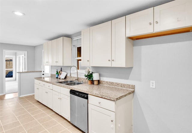 kitchen featuring light tile patterned floors, light countertops, white cabinetry, a sink, and dishwasher