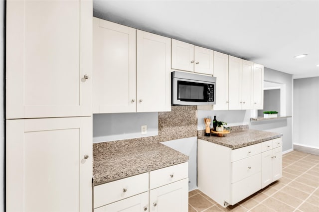 kitchen with light tile patterned floors, recessed lighting, stainless steel microwave, and white cabinetry