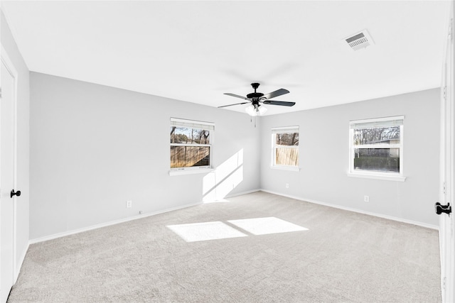 spare room with ceiling fan, baseboards, and light colored carpet