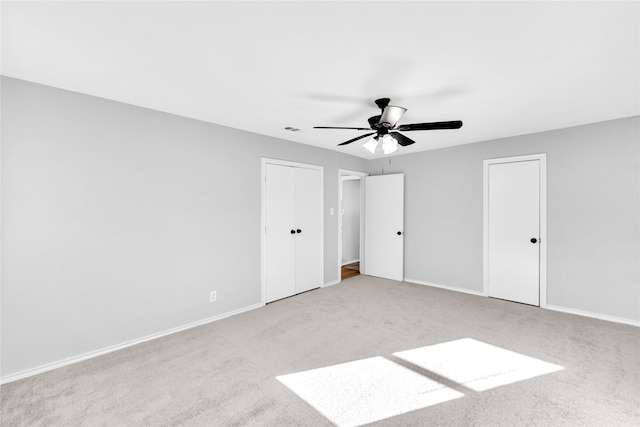 unfurnished bedroom with a ceiling fan, carpet flooring, visible vents, and baseboards