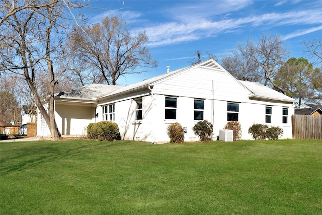 view of side of property with fence and a yard