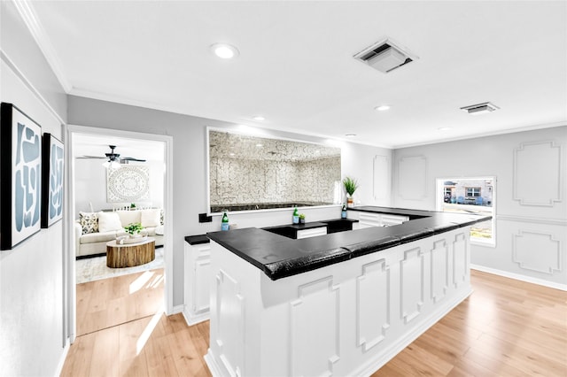 kitchen featuring ornamental molding, dark countertops, visible vents, and white cabinetry