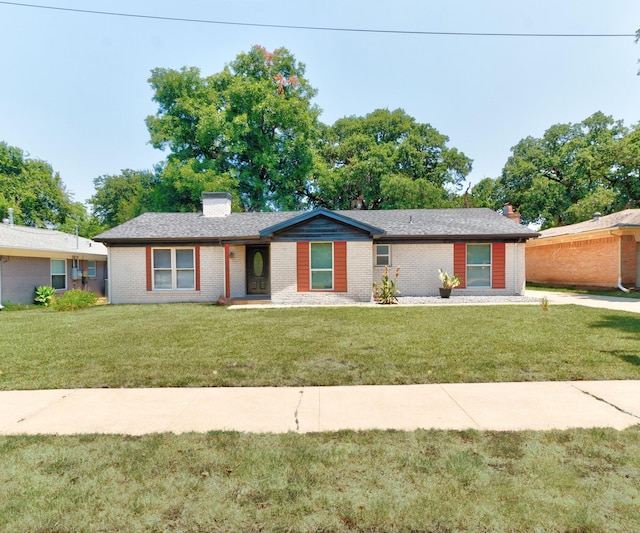 ranch-style home with a front lawn, a chimney, and brick siding