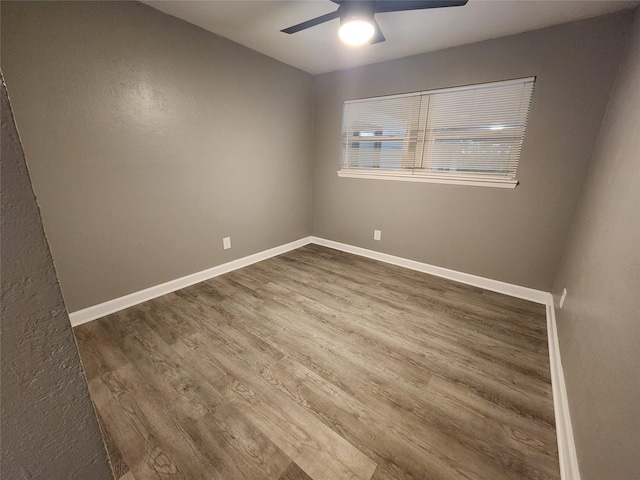 unfurnished room featuring a ceiling fan, baseboards, and wood finished floors