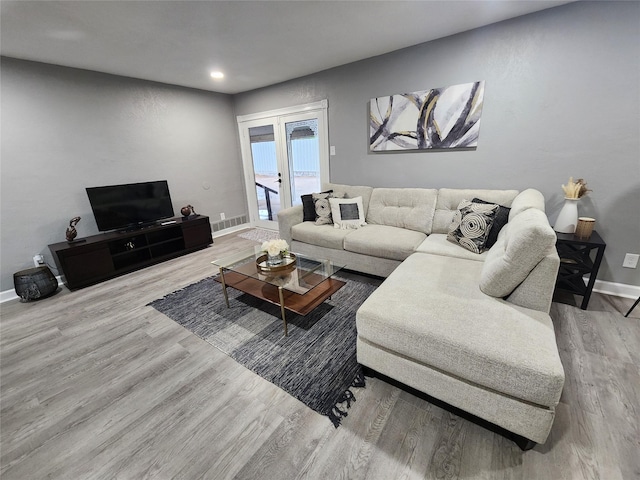 living area with recessed lighting, wood finished floors, visible vents, baseboards, and french doors