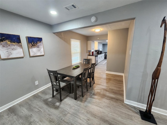 dining space featuring baseboards, visible vents, and light wood-style floors