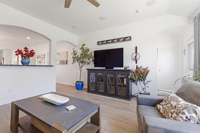 living room featuring vaulted ceiling, wood finished floors, a ceiling fan, and baseboards