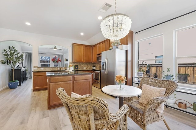 kitchen featuring stainless steel appliances, tasteful backsplash, light wood-style flooring, and visible vents