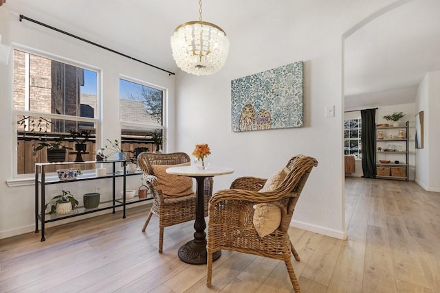 dining room with baseboards, hardwood / wood-style floors, and a notable chandelier