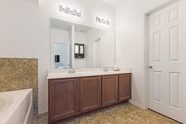 bathroom featuring double vanity, a garden tub, a sink, and ensuite bathroom